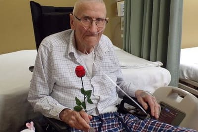 Resident holding a flower in a care facility setting