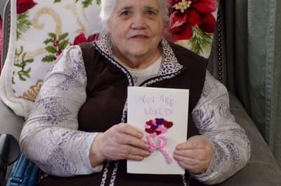 Resident holding a Valentine's Day card with decorations
