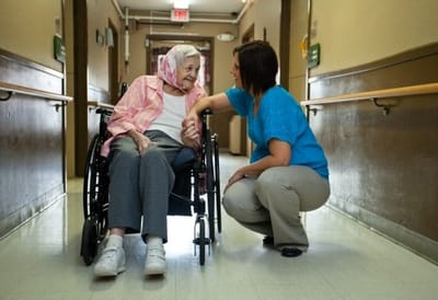 Caregiver interacting with a resident in a hallway