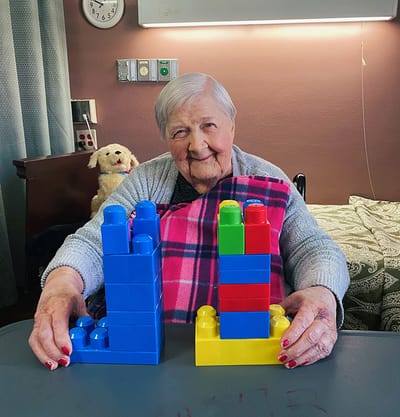 Resident engaged in building with colorful blocks