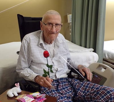 Landmark Nursing & Rehabilitation Ctr of West Mon, Nursing Home in West Monroe, LA — Elderly man holding a rose in a nursing room