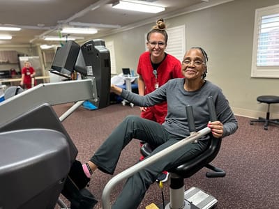 Senior resident exercising with staff assistance