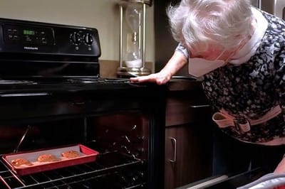 A resident checking cookies in the oven