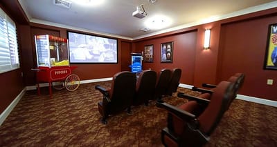 A cozy movie room with seating and popcorn machine