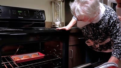 Resident checking cookies in the oven.