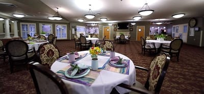 Dining area set up for a meal service with tables and decorations