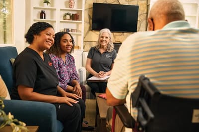 Care staff engaging with residents in a cozy lounge.