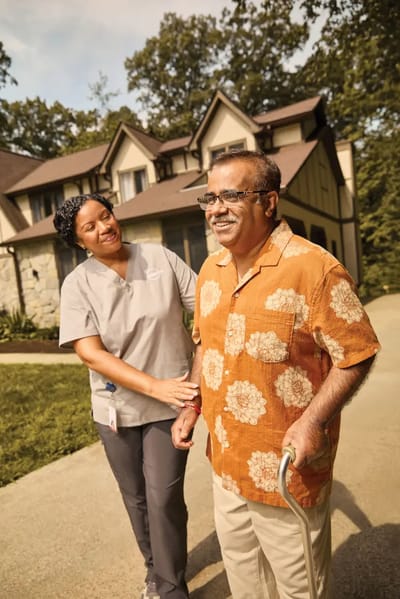 Caregiver assisting a resident outside a facility