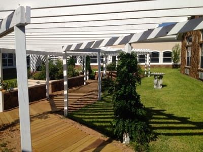 Wooden outdoor path with trellises and garden