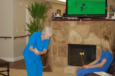 Residents participating in an indoor activity with a gaming console