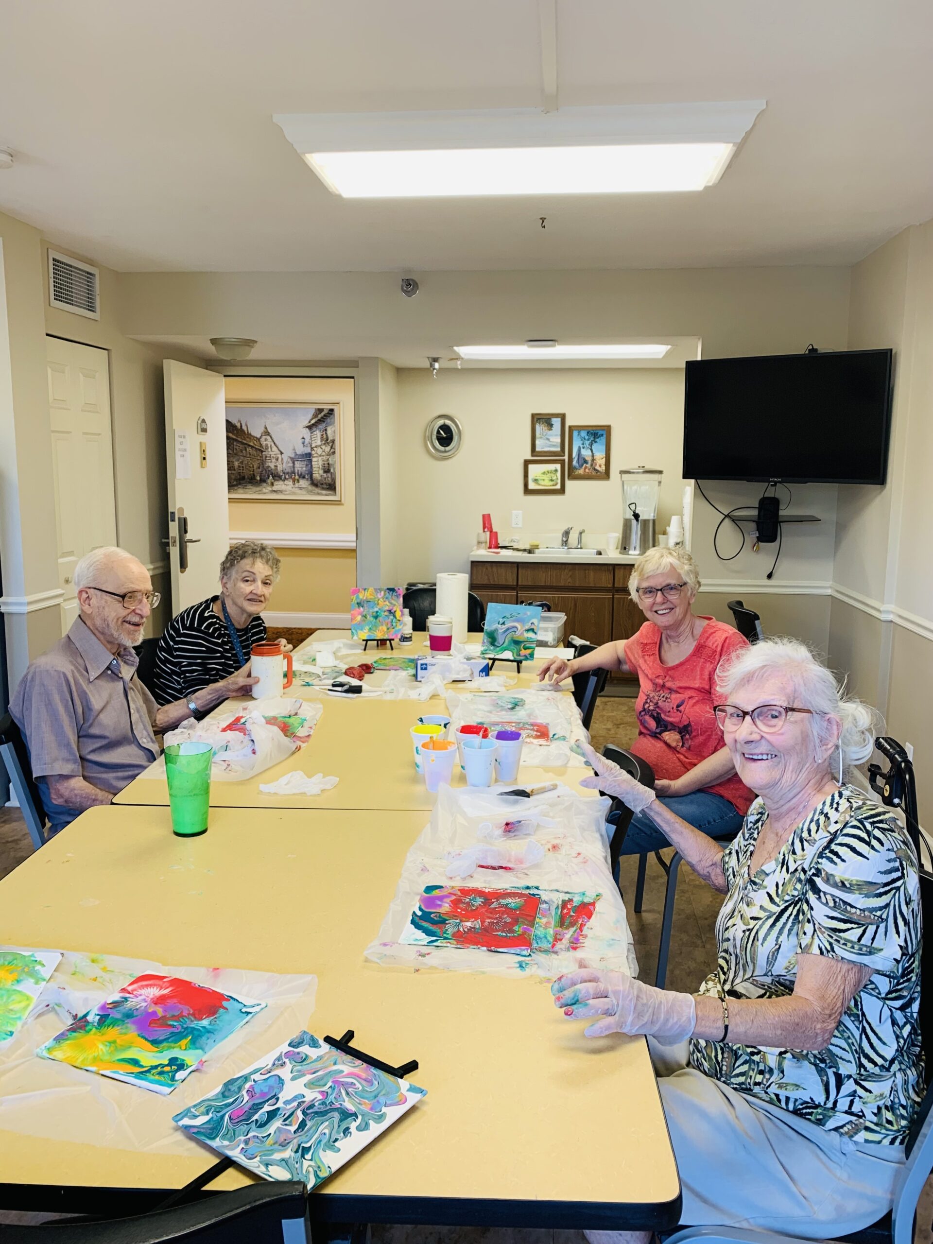Residents engaged in a painting activity at a table