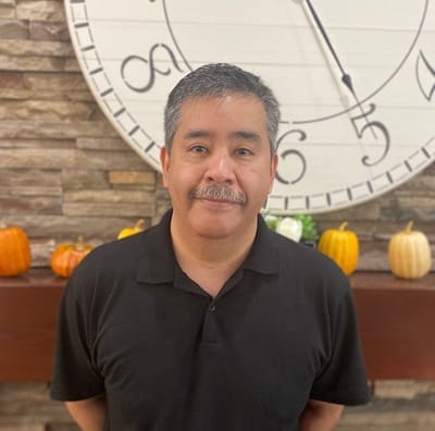 A staff member poses in the facility lobby with decorations