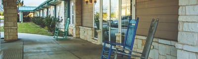 Outdoor seating area with rocking chairs at the facility entrance
