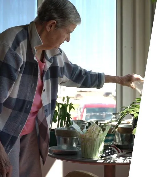 Resident watering plants in a communal area