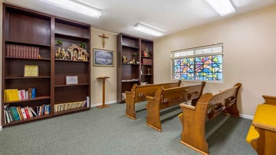 Serene chapel interior with wooden benches and stained glass window