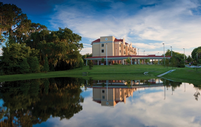 Exterior view of assisted living facility by a pond