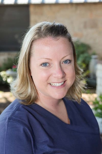 Staff member smiling in a garden setting