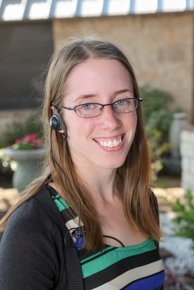 Staff member smiling outdoors with headset