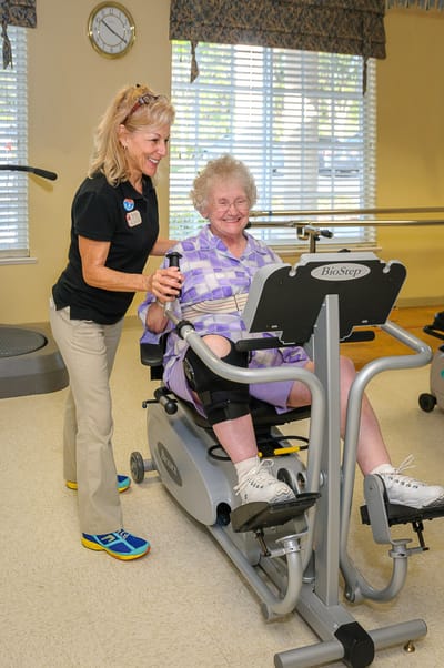 Staff assisting a resident on an exercise machine