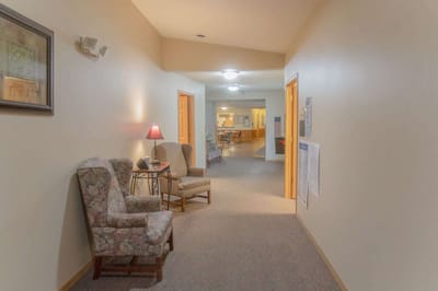 A hallway with floral chairs and soft lighting