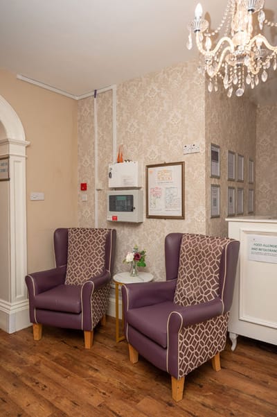 Cozy seating area with purple chairs and chandelier