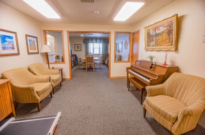 Cozy sitting area with piano and chairs