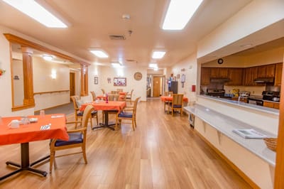 Dining area with orange table settings and wooden furniture