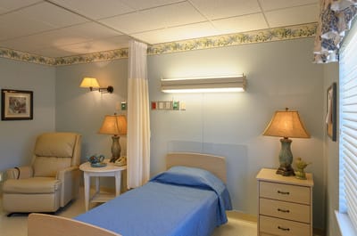A well-furnished resident room with a bed and seating area