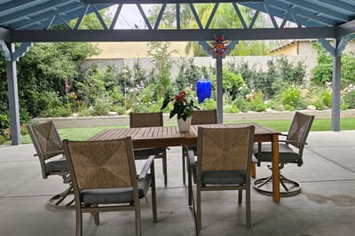 Outdoor seating area under a pergola with garden view