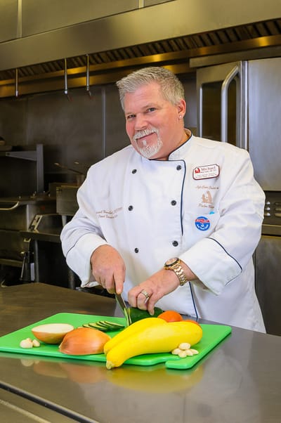 Chef preparing vegetables in a kitchen setting