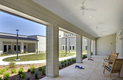 Covered porch area with rocking chairs overlooking a garden