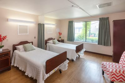 A shared resident room with two beds and window view