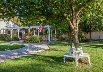 Well-kept garden area with seating and American flag