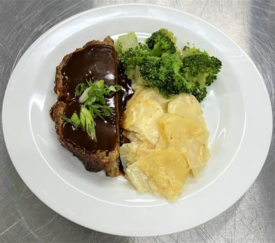 Plate of meatloaf with sides of broccoli and potatoes