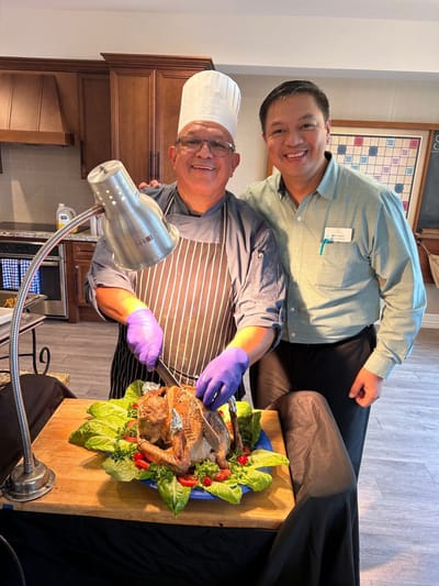 Chef serving a beautifully presented dish with a resident