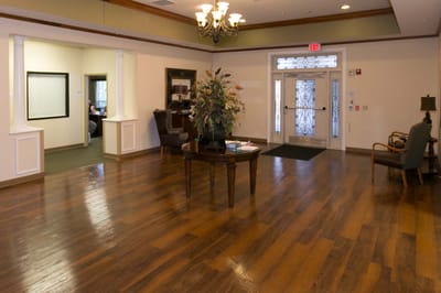 Welcoming lobby area with wooden floors and floral arrangement