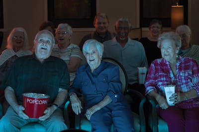 Residents enjoying a movie night with popcorn