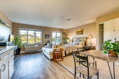 A cozy resident room featuring a bed and seating area