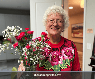 Resident smiling and holding a flower bouquet
