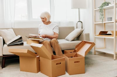 An elderly woman organizing boxes in a cozy living room