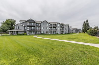 Exterior view of a senior living facility with green lawns