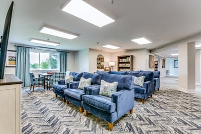 Common area with blue armchairs and natural light