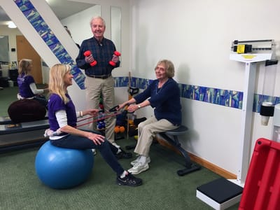 Residents participating in a fitness activity with staff assistance