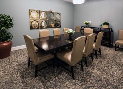A well-furnished common area with a large table and seating