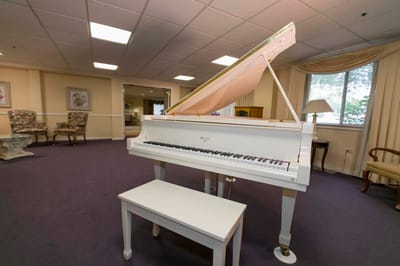 A white piano in a cozy lounge area