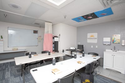 A classroom setting with tables and chairs at Sandstone of Tucson