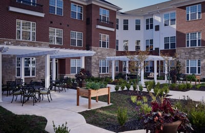 Outdoor seating area with gardens and building facade