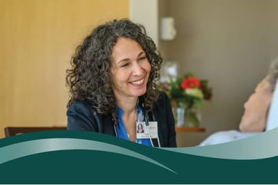 A staff member smiling while talking to a resident