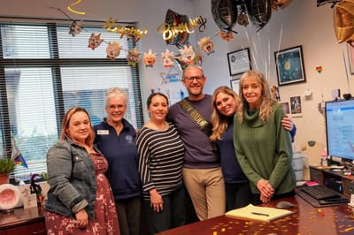 Staff celebrating a resident's birthday in a decorated office