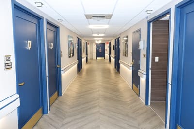 Interior hallway with blue doors and ample lighting